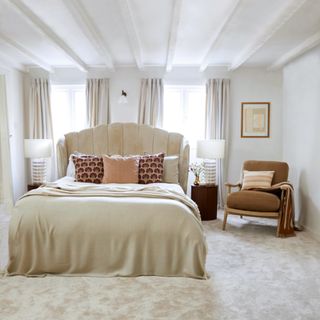 Neutral bedroom with white painted beams and a cream plush carpet