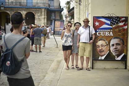 Tourists pose ahead of President Obama's historic visit with Raúl Castro