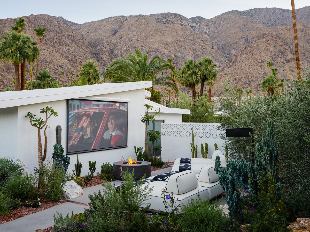 fall backyard ideas; backyard with cinema screen and firepit by Ryan Saghian