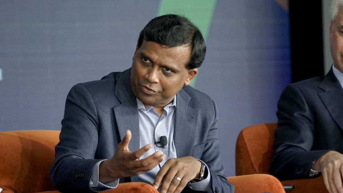 Ravi Kumar, sat in a chair, speaking during a panel discussion at an event