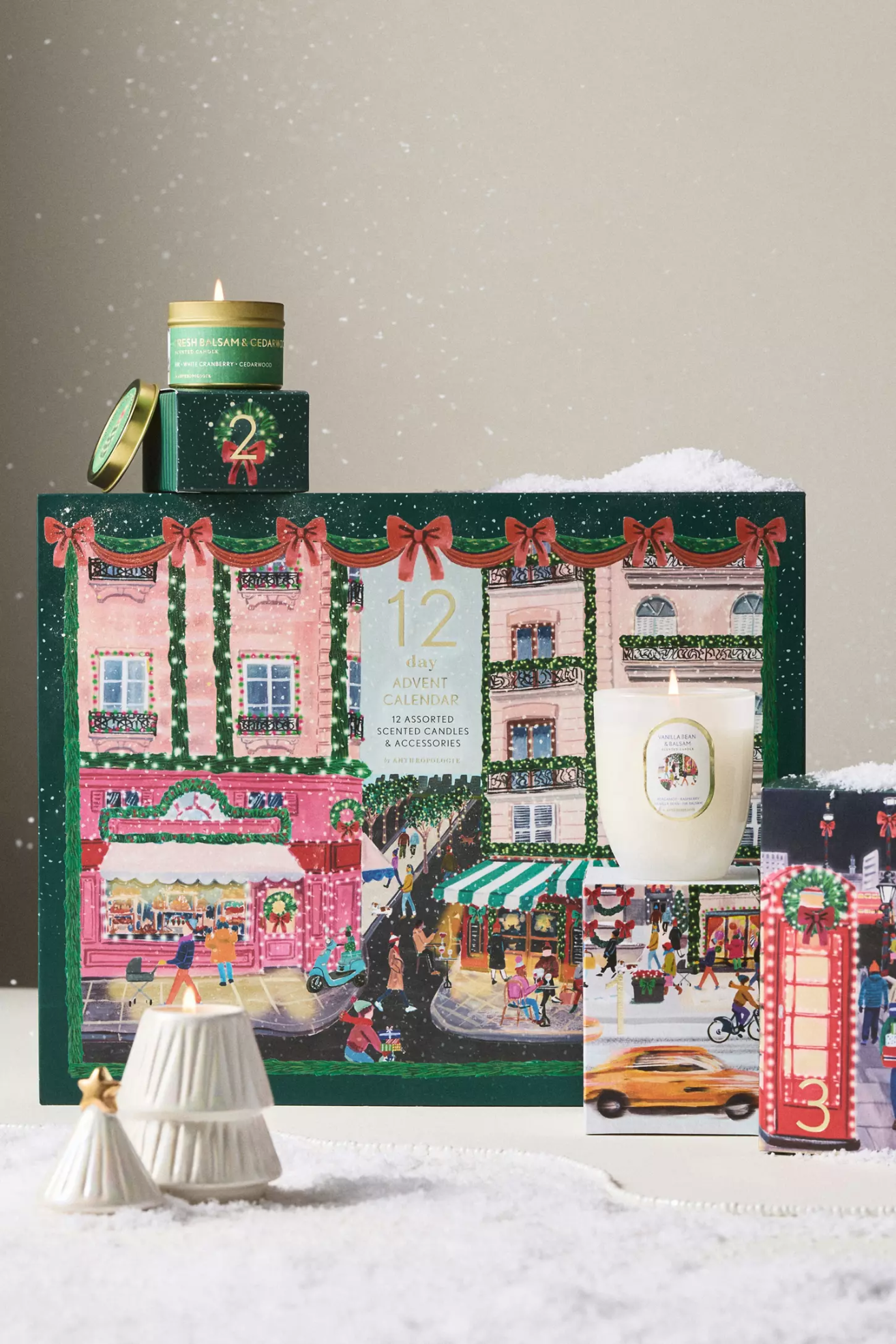 A green advent calendar with a tree-shaped candle, a tin candle, and a glass candle