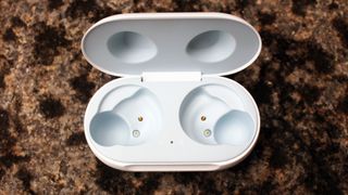 The Samsung Galaxy Buds case with no buds inside on a brown surface