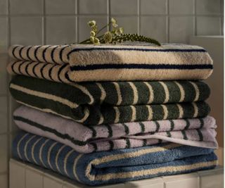 Brooklinen Super-Plush Bath Towels stacked on top of a bathroom dresser.