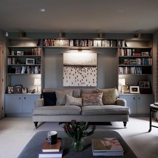 Living room with huge lowrey painting and grey sofas