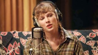 Taylor Swift sings into a microphone in Folklore: The Long Pond Sessions