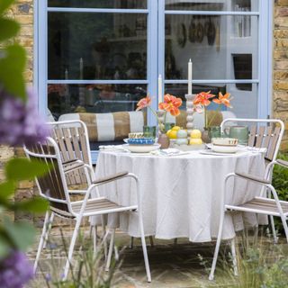 outdoor table with white chairs and dining set-up