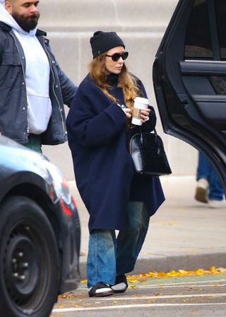 Ashley Olsen wears socks and sandals and a cocoon coat in New York City