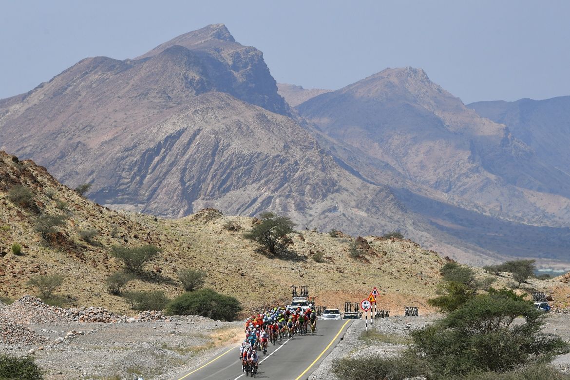 The mountains loom behind the riders