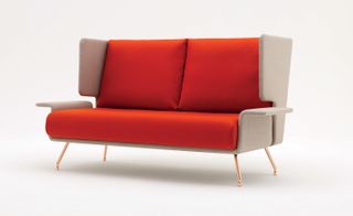 Orange padded sofa with high back rest and arm rests