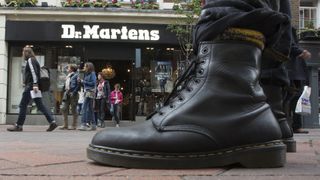 A person wearing a pair of doc martens stands in front of a docs store