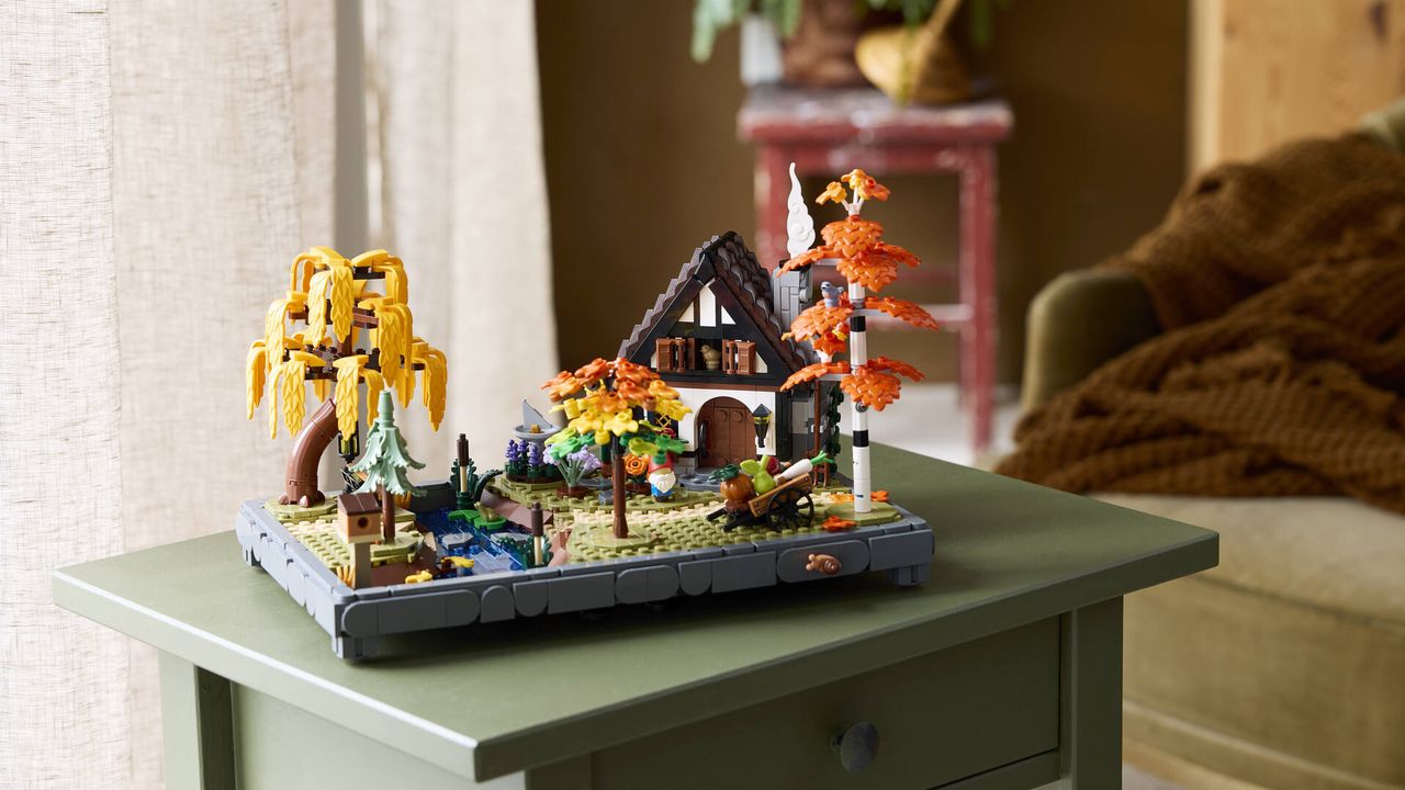 A Lego cottage and garden laid out on a small side table