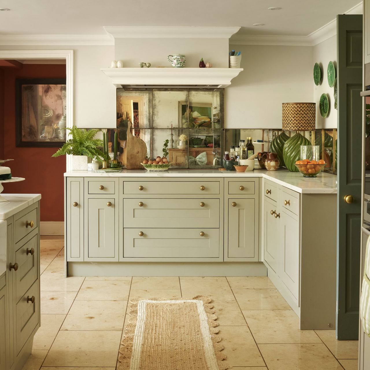 kitchen with pale sage green cabinets and antiqued mirrored splashback