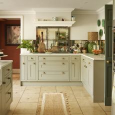kitchen with pale sage green cabinets and antiqued mirrored splashback