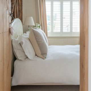 neutral coloured bedroom with white duvet set on bed