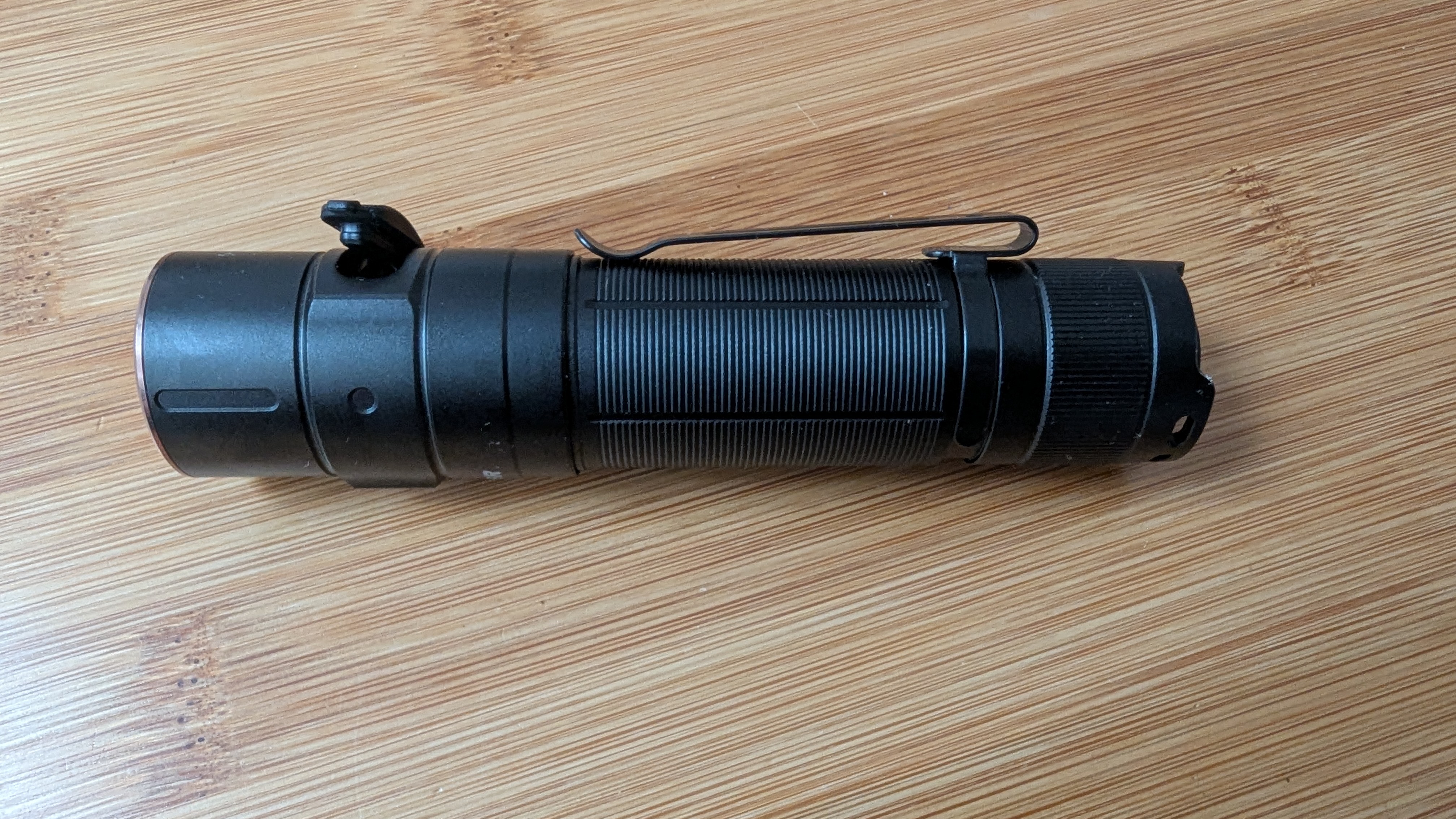Fenix E35R flashlight during review showing the pocket clip and USB-C cover.
