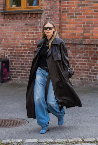 Woman wearing barrel jeans, top and trench coat