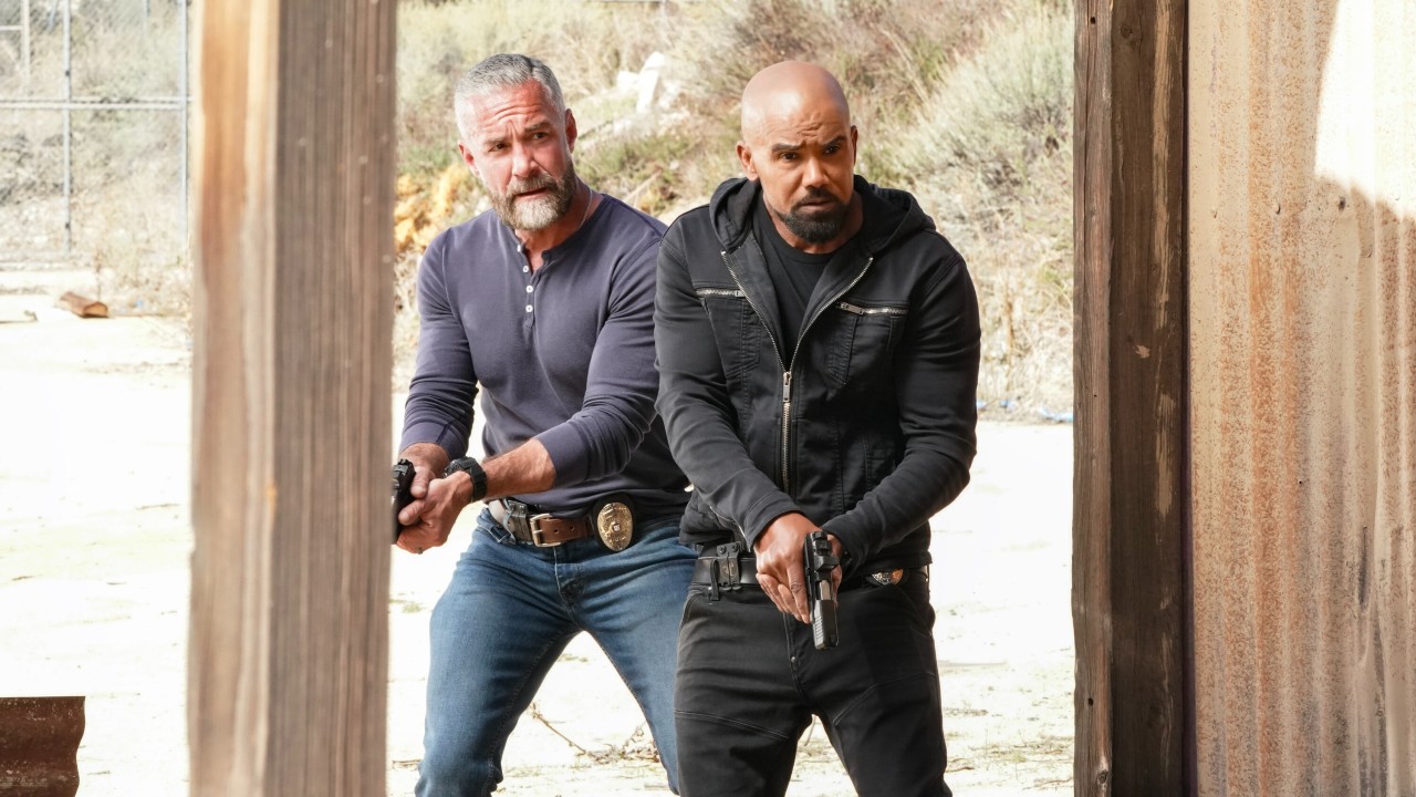 From left to right: Jay Harrington holding a gun with both hands toward his left and Shemar Moore holding a gun with both hands in front of him on S.W.A.T.