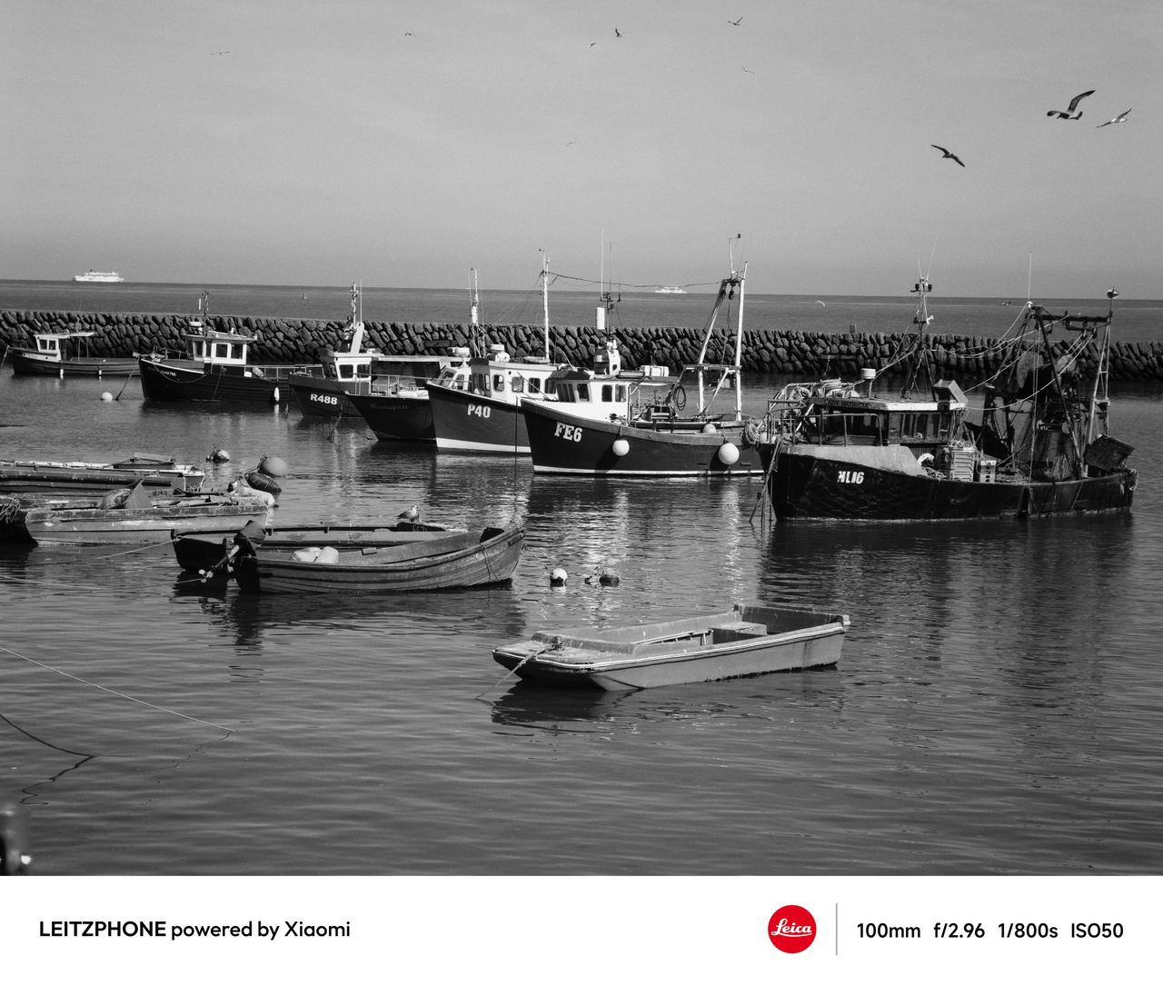 Black-and-white photo of fishing boats moored in a harbor