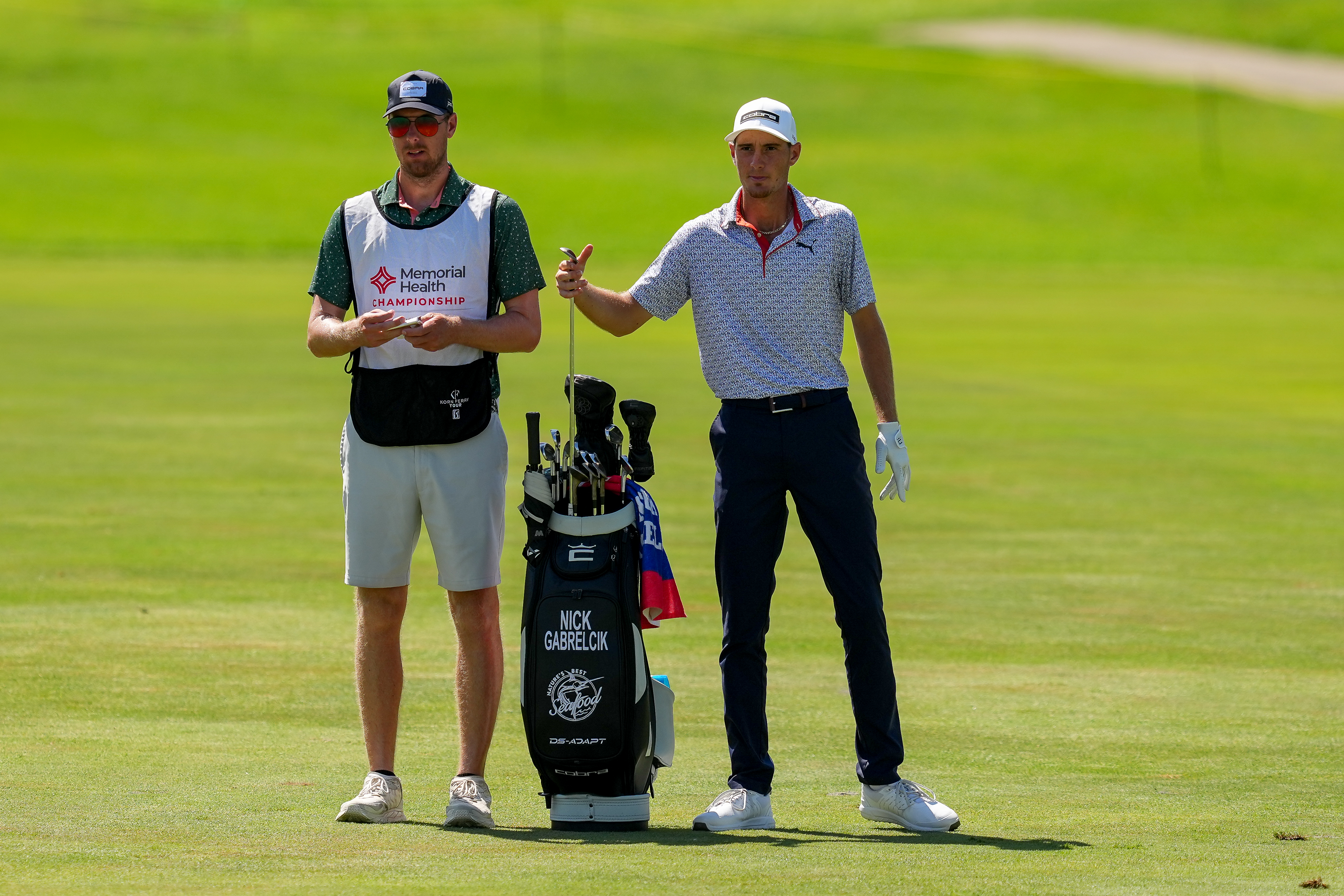 A player speaks to his caddie