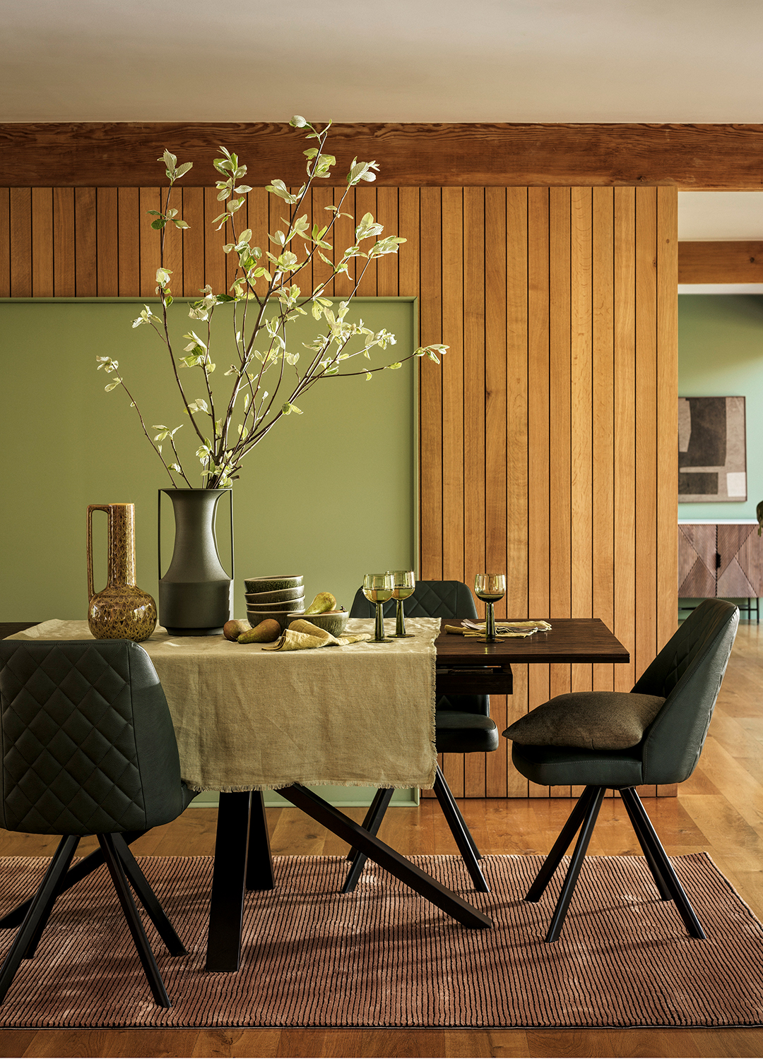 natural dining room with wood panelling and sage green painted walls
