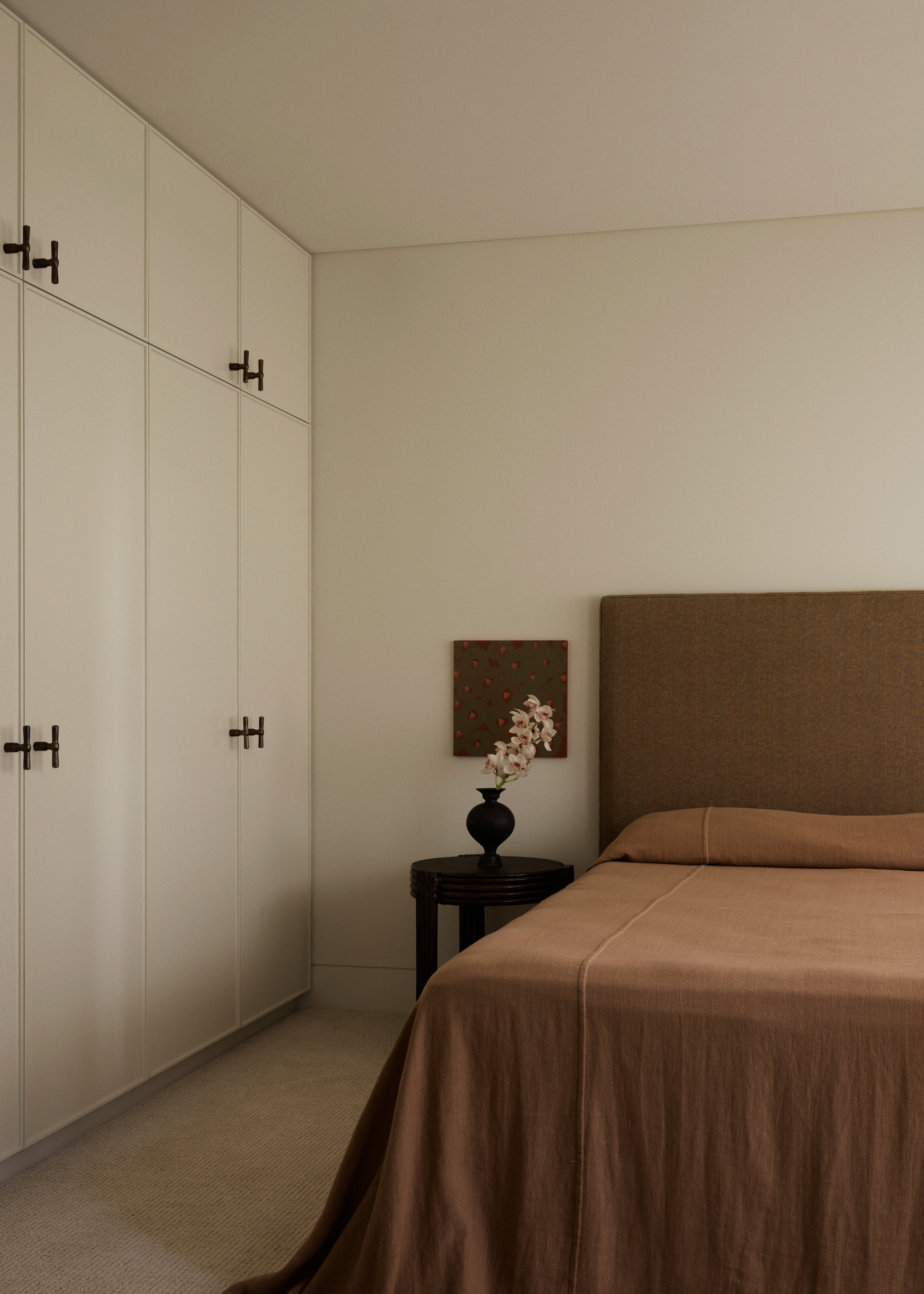 A bedroom with a white clothes closet and stylish handles