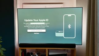 A TV showing a message requesting that an iPhone be used to accept Apple TV terms and conditions