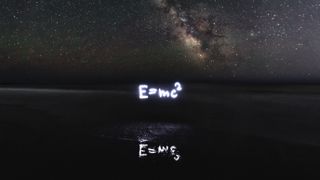 special relativity equation e=mc2 written in light with the milky way in the background and the equation reflected in water below.