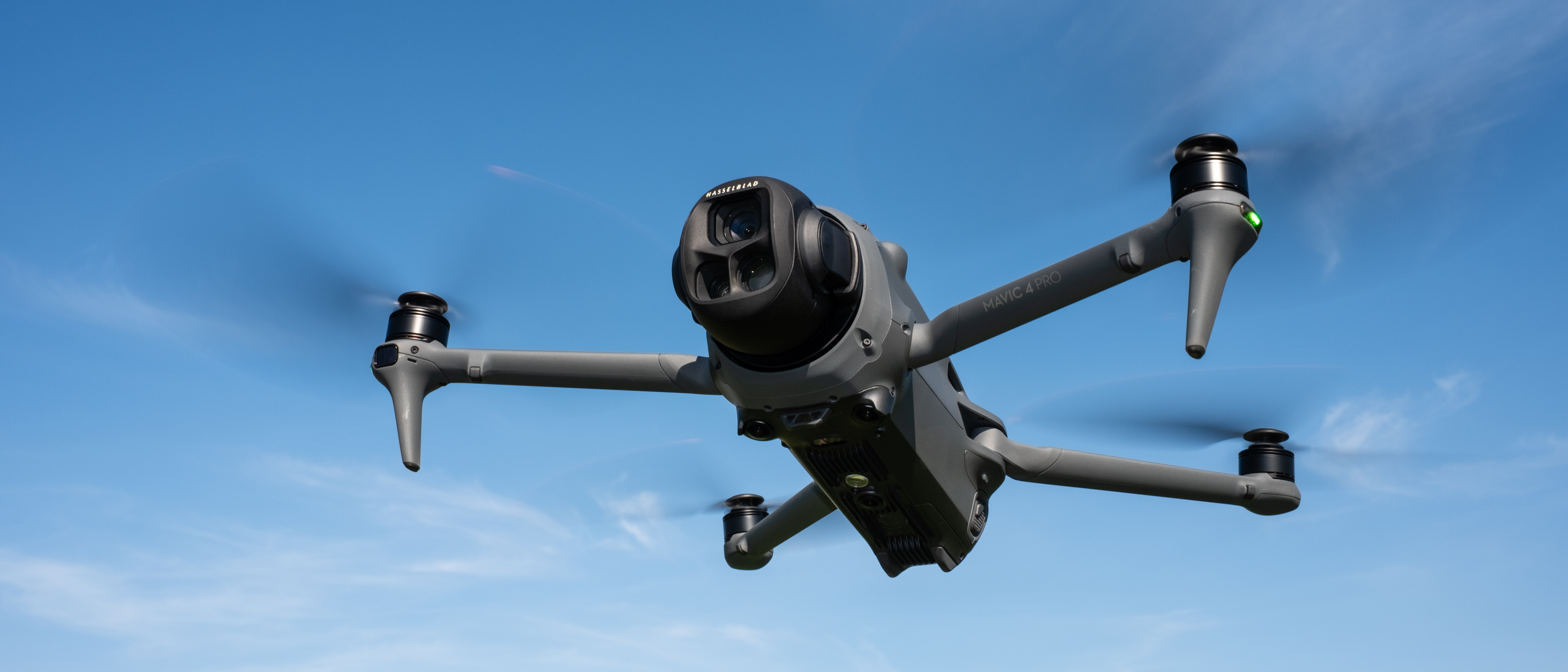 DJI Mavic 4 Pro in flight against a blue sky