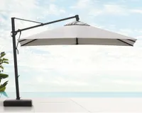 An off-white cantilever umbrella with a black base by the side of a swimming pool