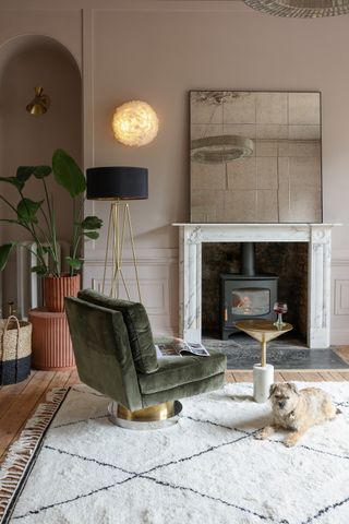 neutral living room with oversized mirror on mantel, retro chair floor lamp, white and black rug