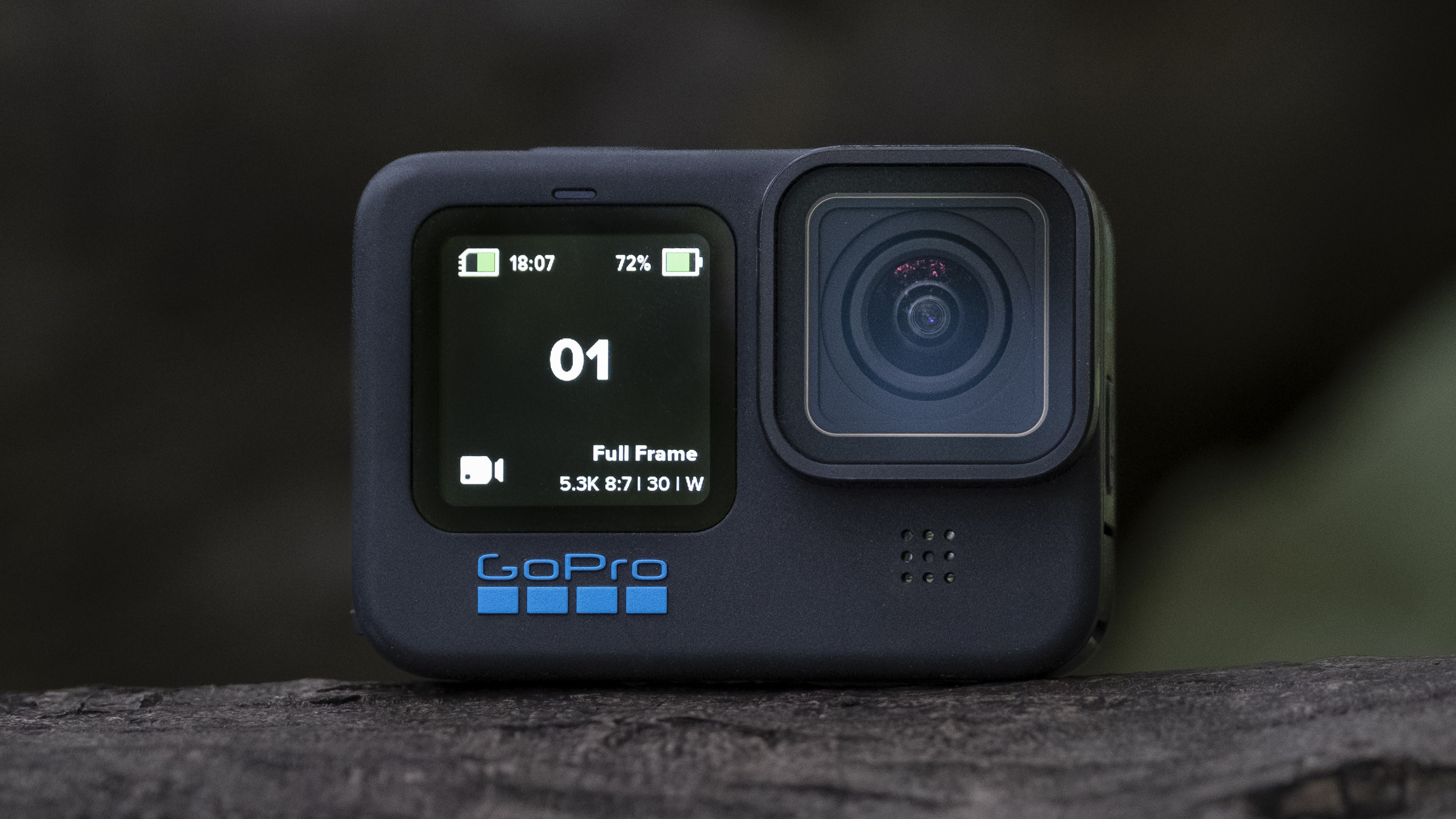 Et actionkamera av typen GoPro Hero 11 Black på en flate av tre.