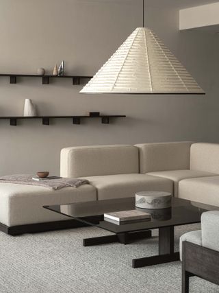 A light living room in the Karimoku Case Study house featuring a pendant lamp, gray carpet and a cream coloured corner sofa