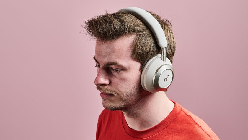 A man wearing the Anker Soundcore Space One Pro in front of a pink wall