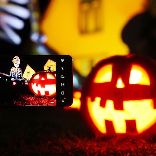 halloween house with mobile phone and pumpkins
