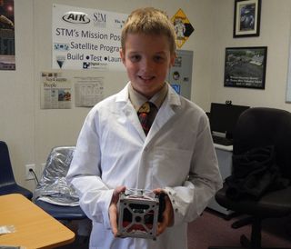 A St. Thomas More Cathedral School student with the school’s STMSat-1 Earth-imaging CubeSat. Will other students get this same opportunity?