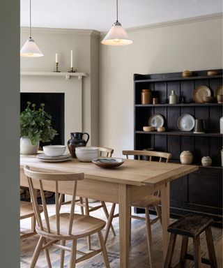 modern transitional dining room with original floorboards, fireplace and antique dresser