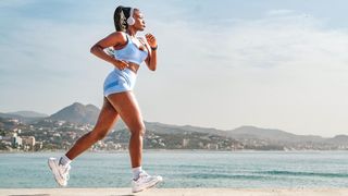 a photo of a woman running along a scenic beach front