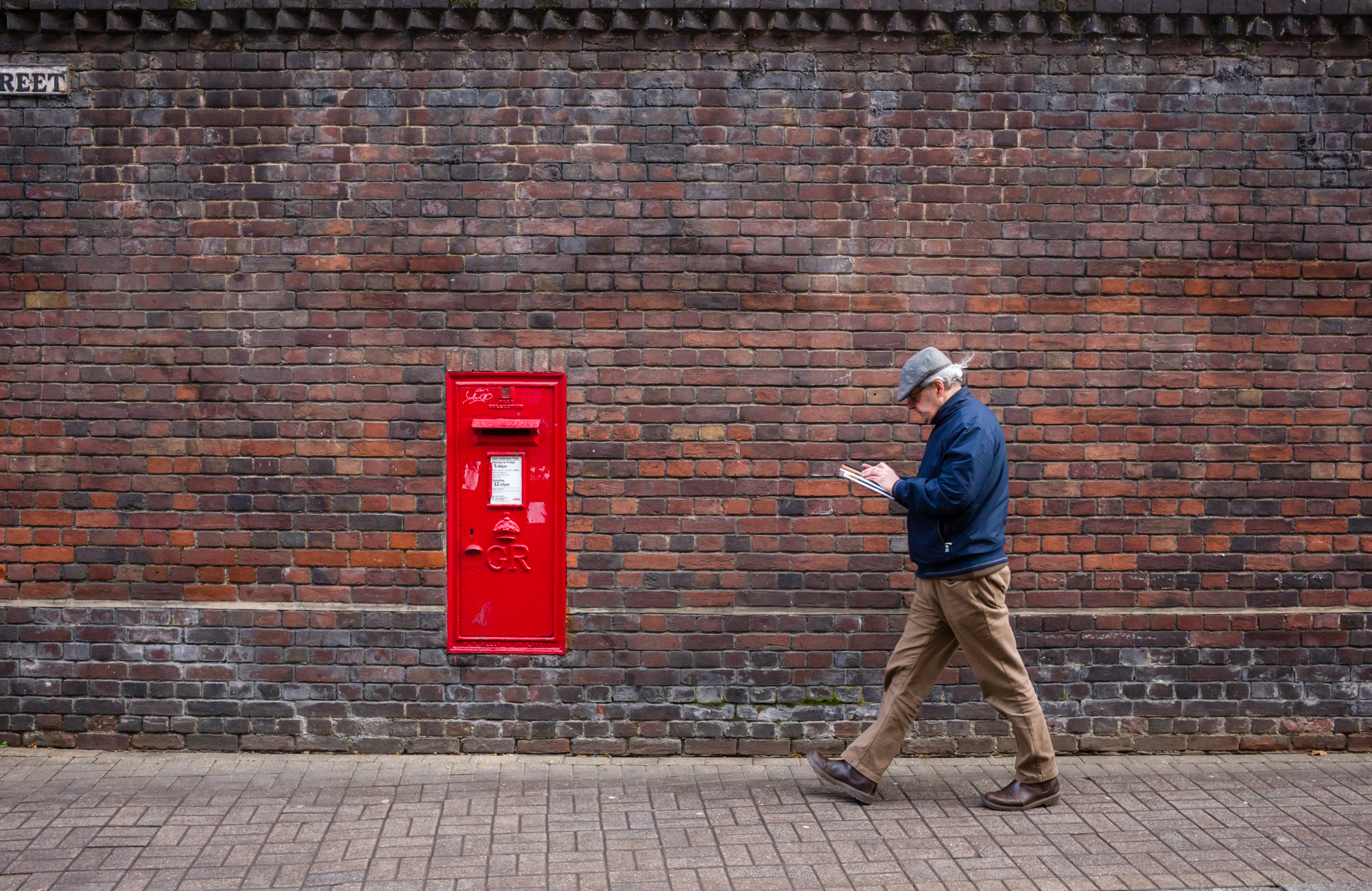 A person walking towards a postbox shot on the Leica M11