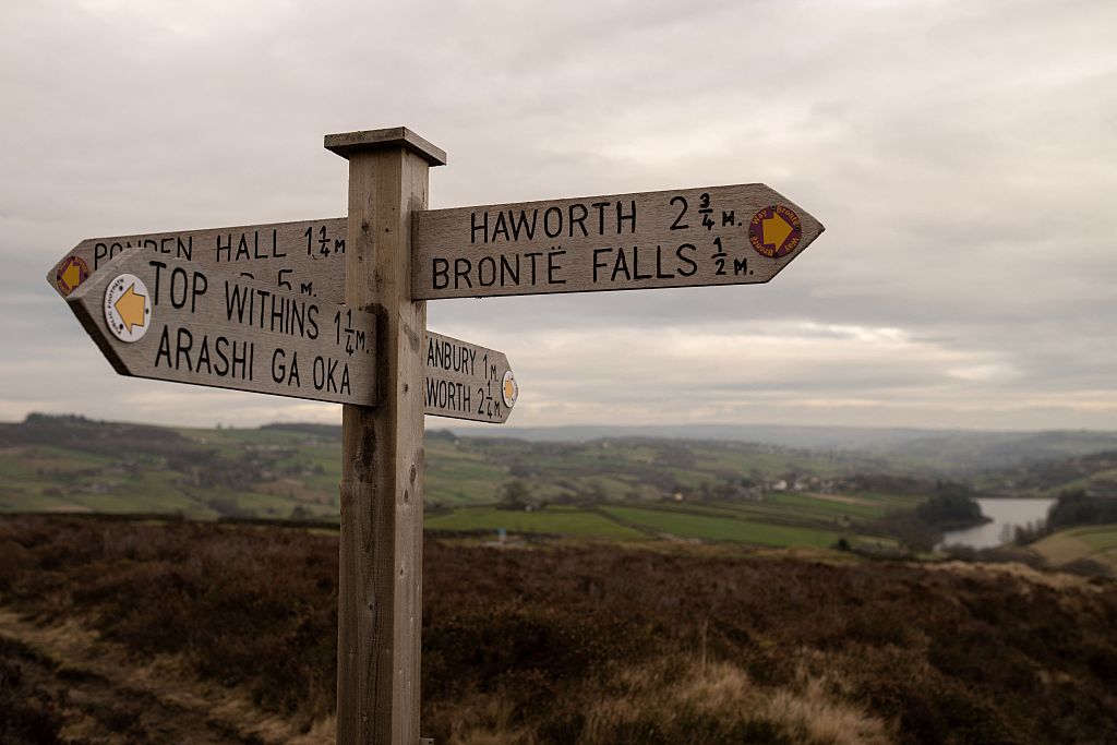 A footpath sign marking the direction to 'Top Withins', a ruined farmhouse notable for its association with Emily Bronte's novel 'Wuthering Heights'
