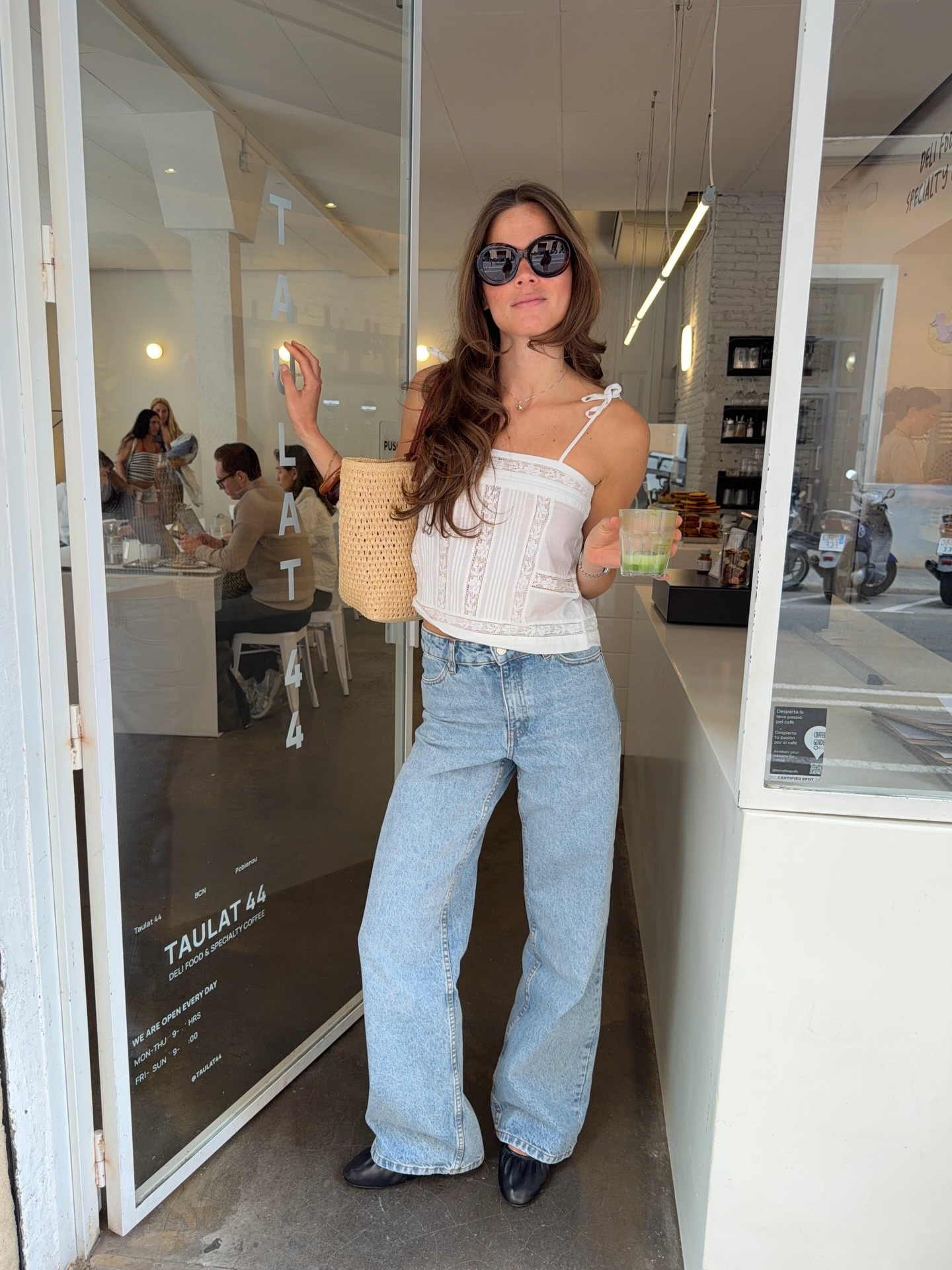 Woman in a white lace top and jeans.