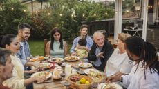A multigenerational family having dinner together outside.