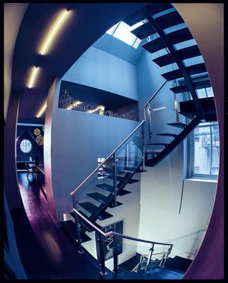 Leading up to a roof deck and down to the bedroom and Pearlstine’s study, the staircase features an alcove filled with 1960s candleholders by Fritz Nagel