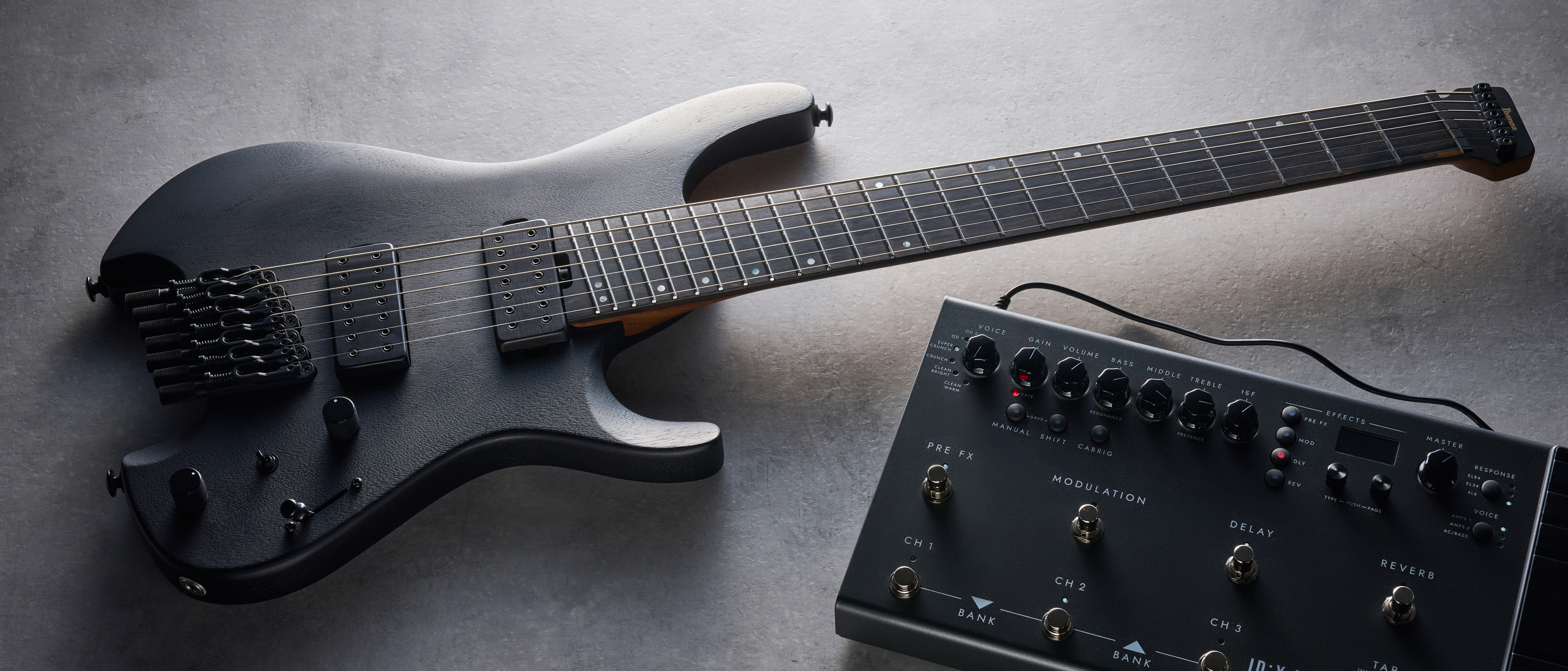 Ibanez QX527B headless guitar shot on grey surface