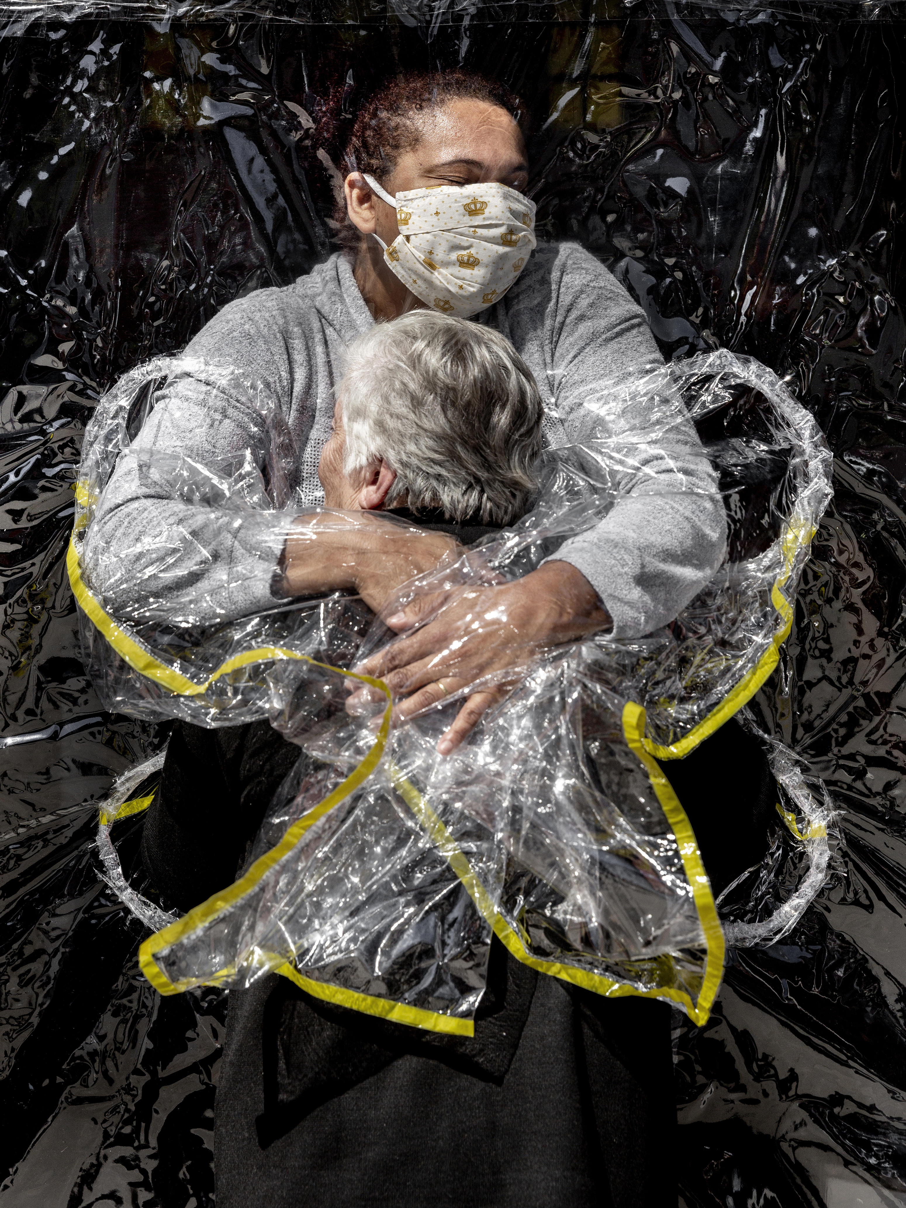 A woman being hugged through a 'hug curtain'