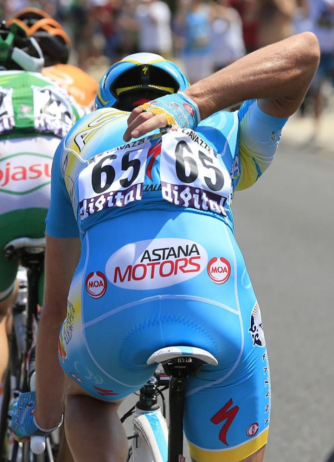 An Astana rider shuffles contents of his pocket