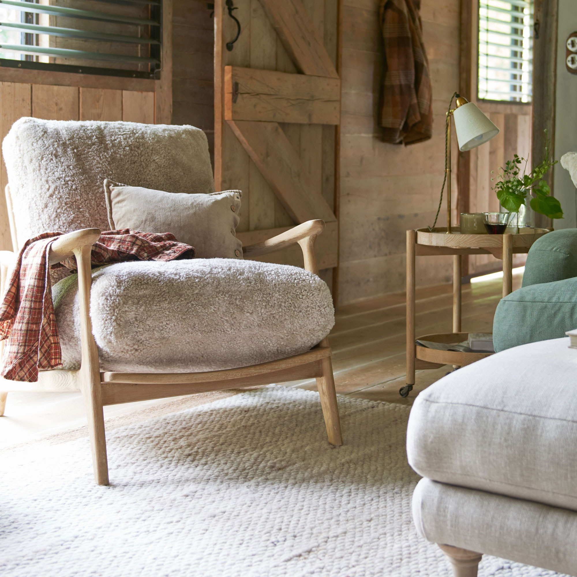 cosy Scandi style living room with fleece armchair and pale wood panelling on walls