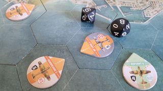 The plane tokens of Undaunted: Battle of Britain engage in combat near the coast