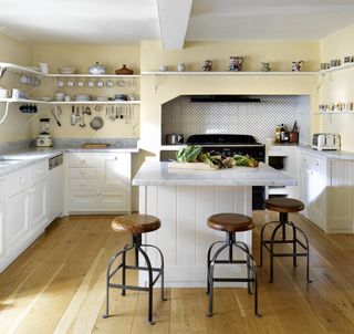 Yellow walls and white kitchen island, base cabinets and shelves