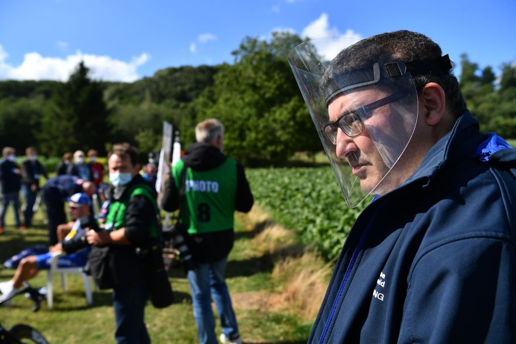 One man wears a face shield to watch the race