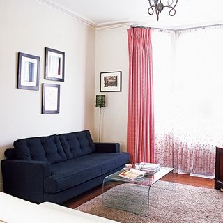 living room with navy blue sofa pink long curtain and span table